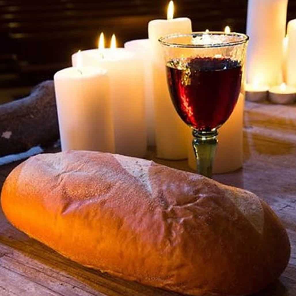 St. John's United Church | A loaf of bread and a glass of wine on a wooden table.