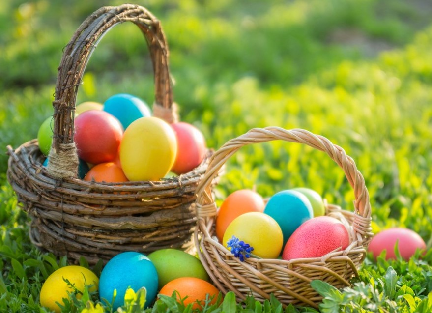 St. John's United Church | Two wicker baskets filled with colorful easter eggs on a grassy field.