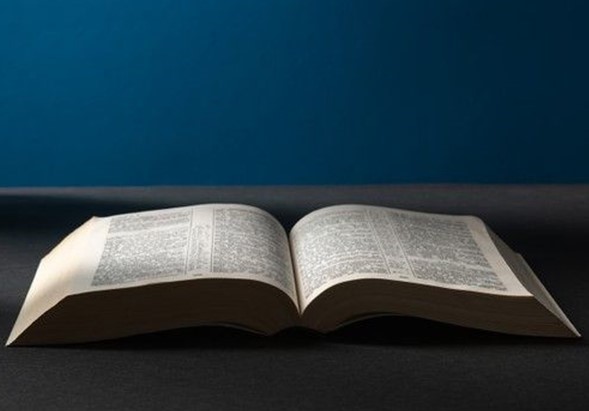 St. John's United Church | An open book with text visible on its pages is placed against a dark blue background.